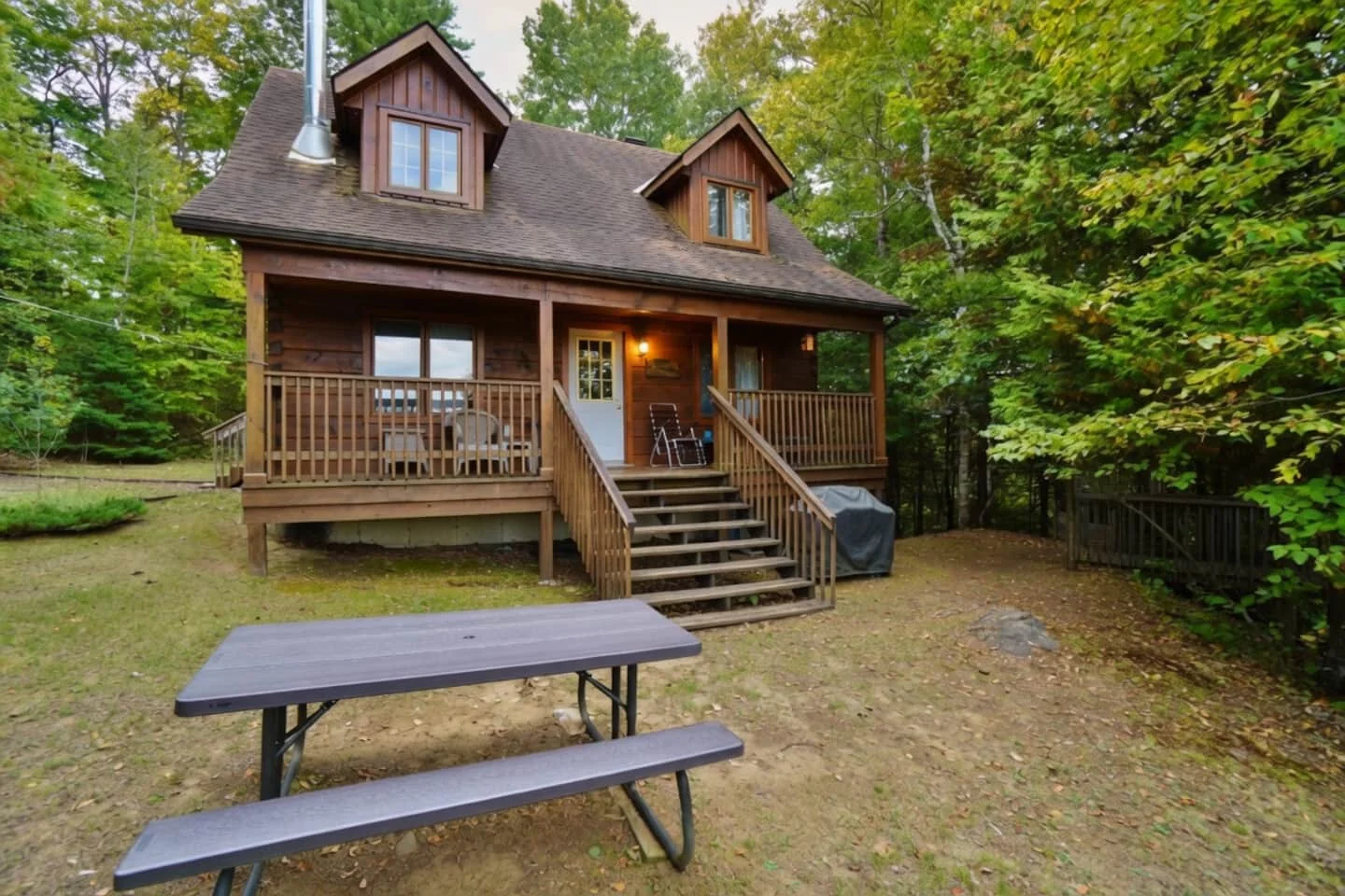 Timber Ridge's wooden cottage and covered porch, surrounded by trees